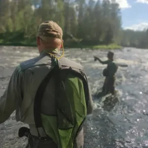 Perhokalastusopas antamassa yksityisopastusta kalastajalle joella.